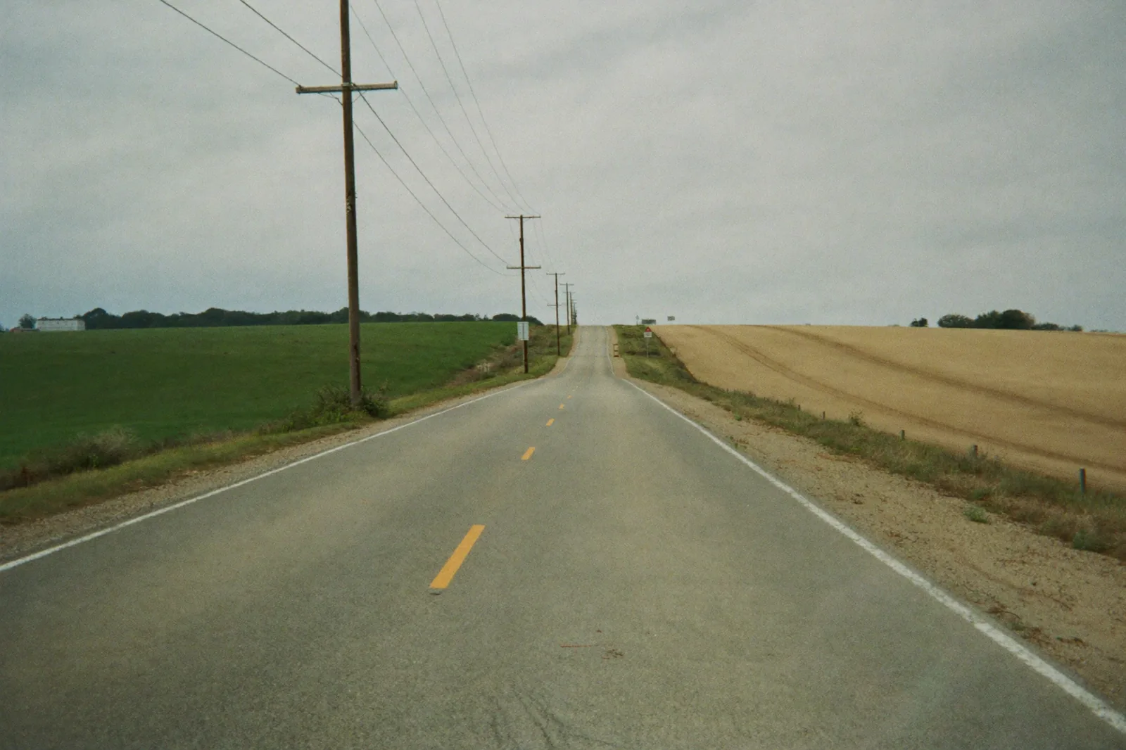 A two-lane road crossing open farm country, the kind that runs between Pennsylvania and Maryland